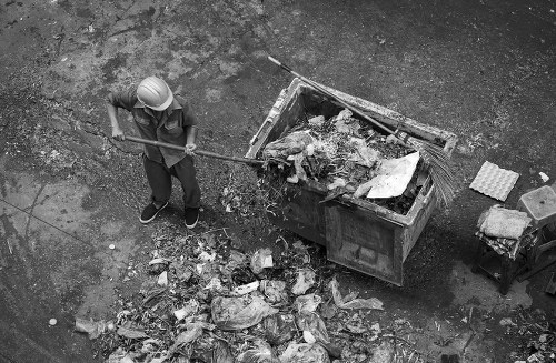 Person placing a skip container in a residential area of Greenwich